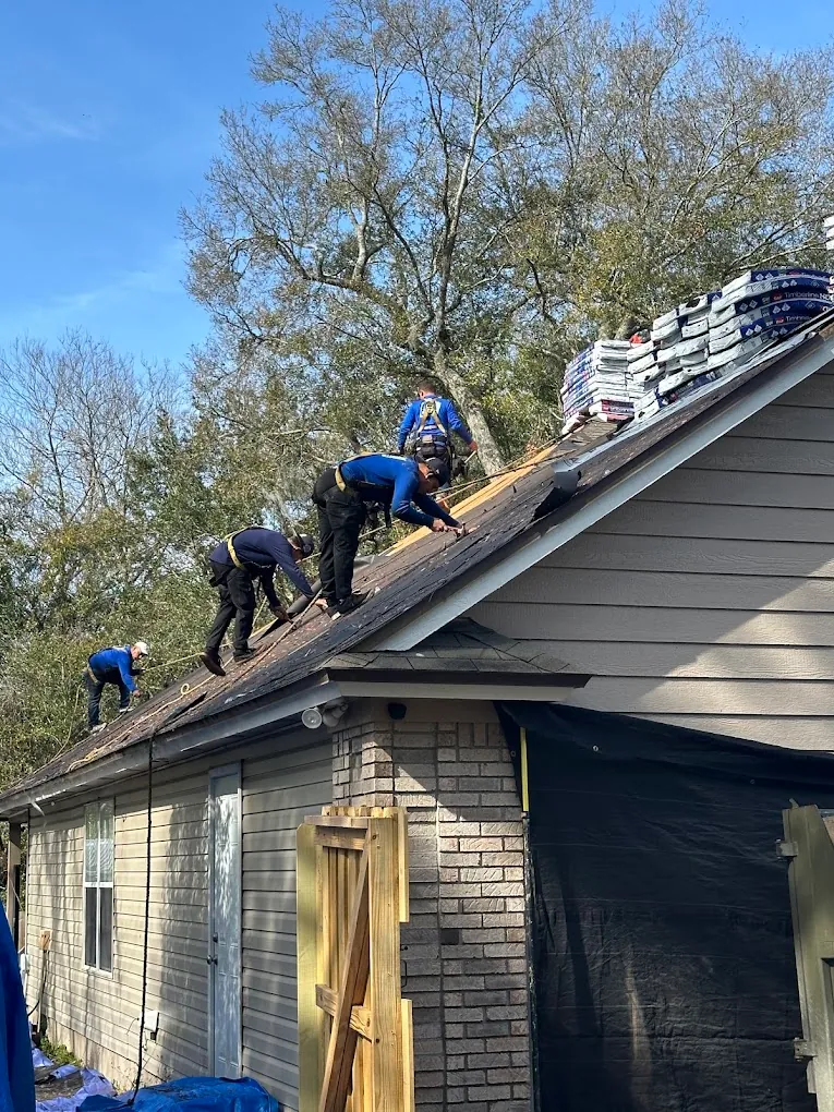 Roofing crew working on a sloped residential roof.