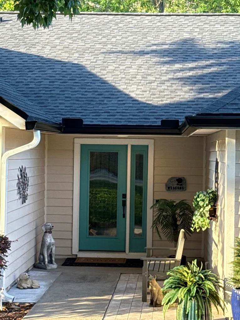 Home entry and roofline with black and white gutter sections.